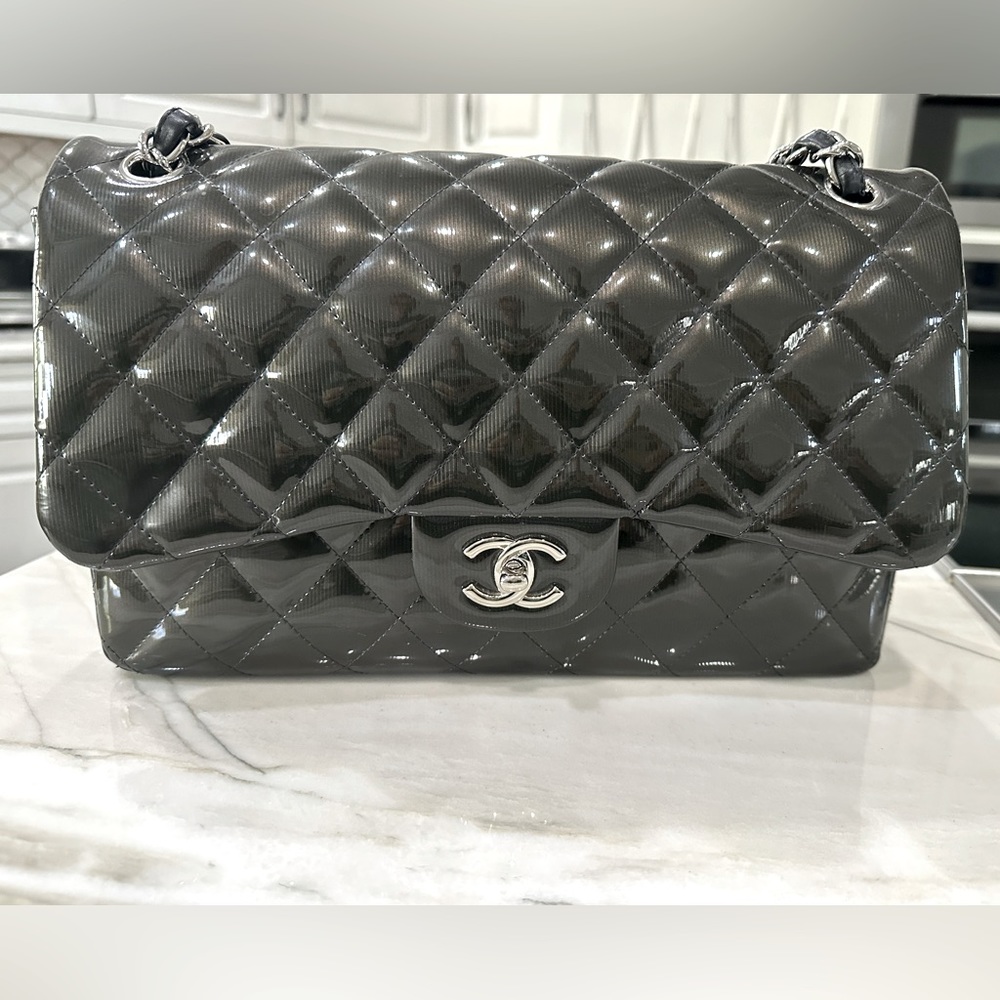 Authentic CHANEL jumbo classic flap is striated patent leather silver hardware